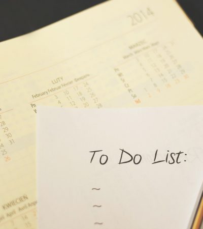 A handwritten to do list on a white piece of paper on top of a calendar