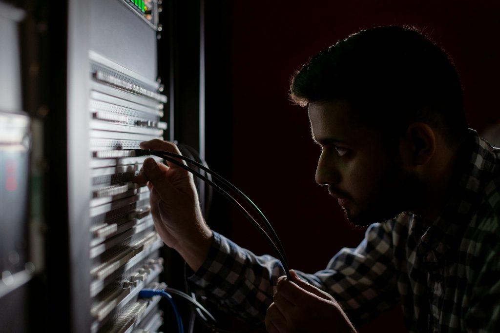 Person disconnecting a network cable from a server rack